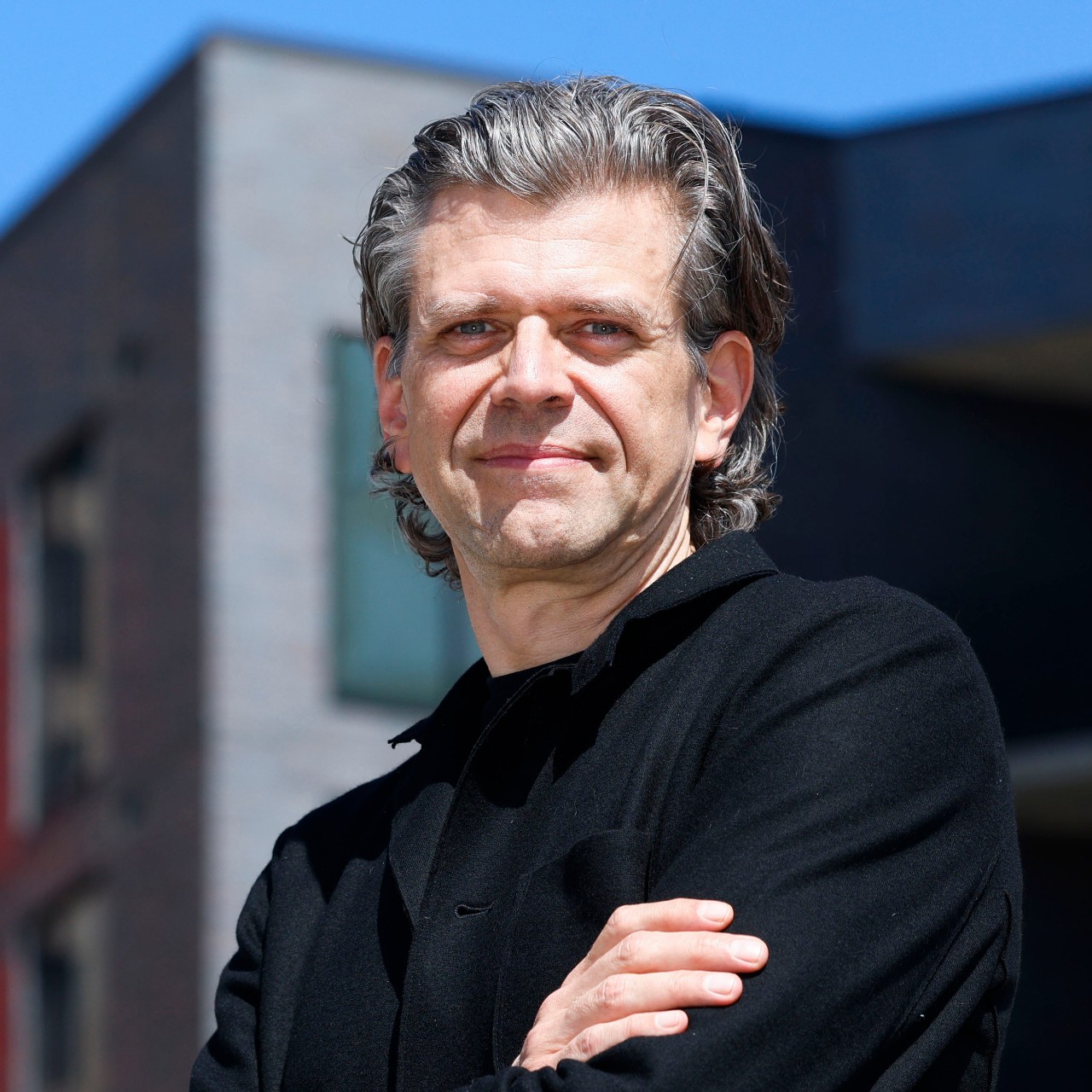 Architect Ron Stelmarski stands in front of the Galbraith apartments, one of his projects, on Tuesday, March 14, 2023 in downtown Dallas.