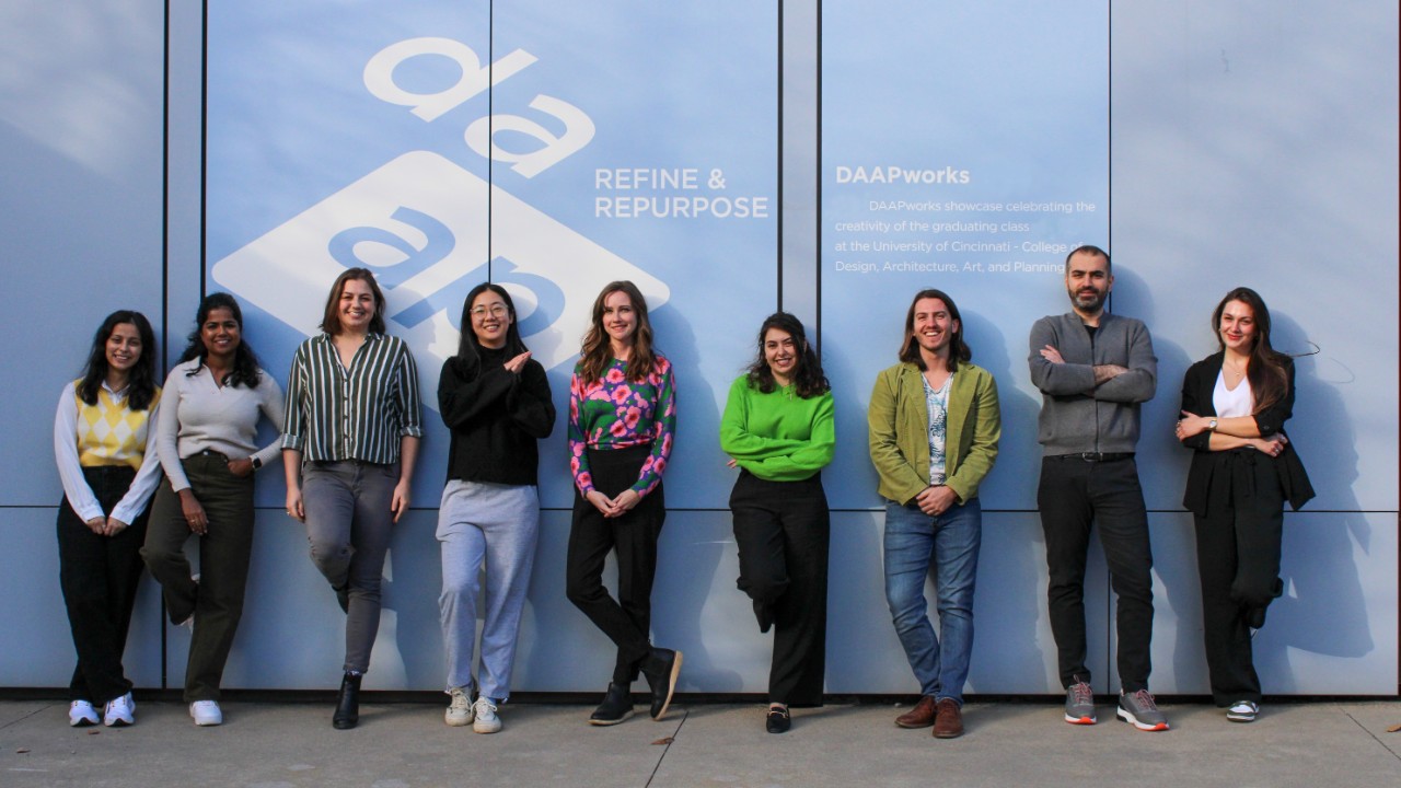 Group photo of MLA Class of 2024 outside of DAAPworks branding on fifth floor of DAAP.