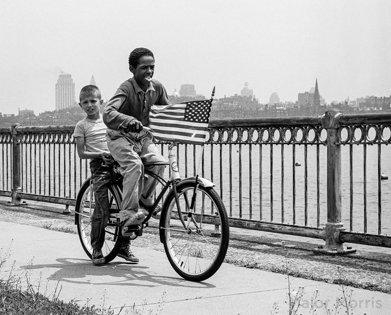 Two boys on bike with flag