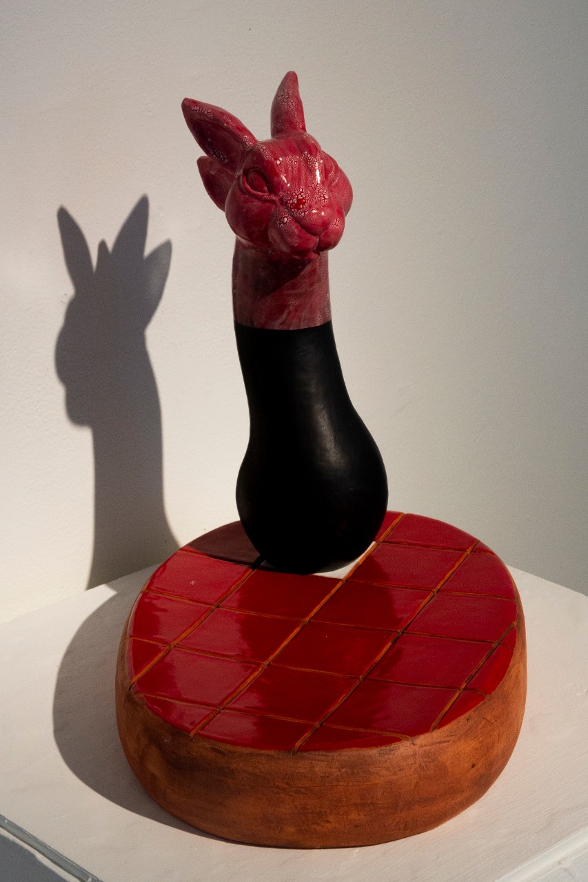 red glazed ceramic bunny head on top of red ceramic glazed slab