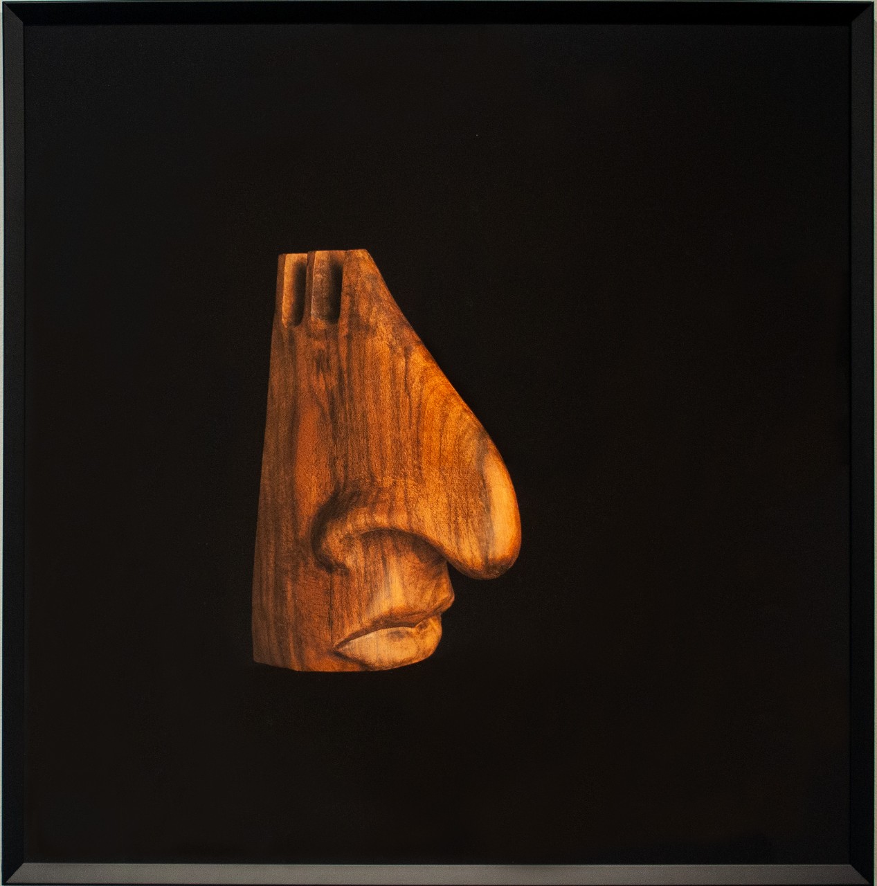 Image of a wooden stand resembling a face used to hold a person's glasses