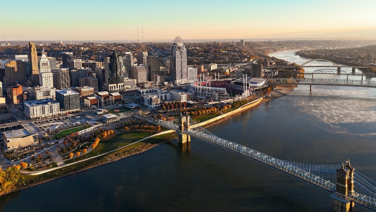 SkylineDrone photo of Cincinnati city skyline from above the Ohio River. Roebling Suspension Bridge