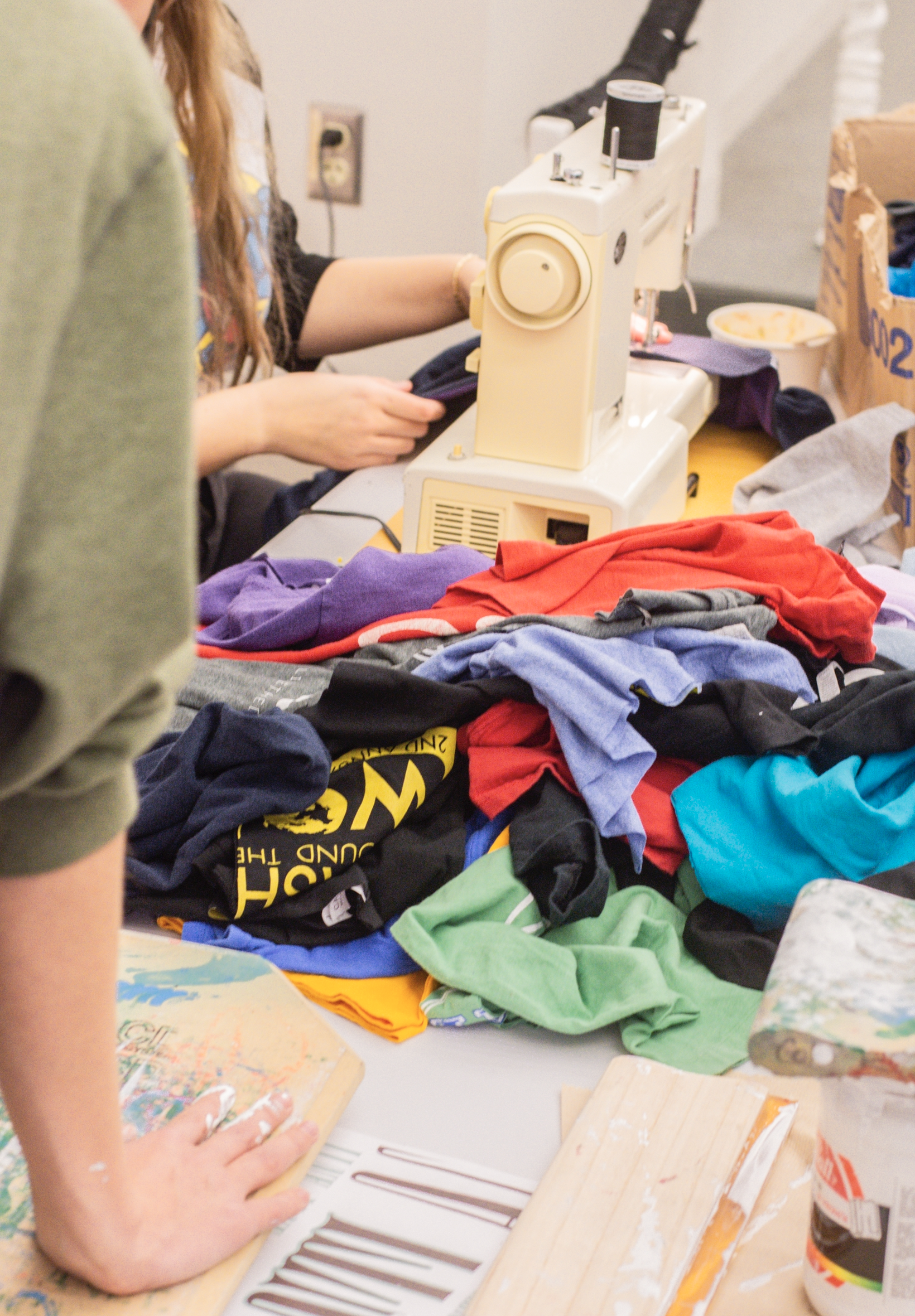Hands using sewing machine to sew fabric