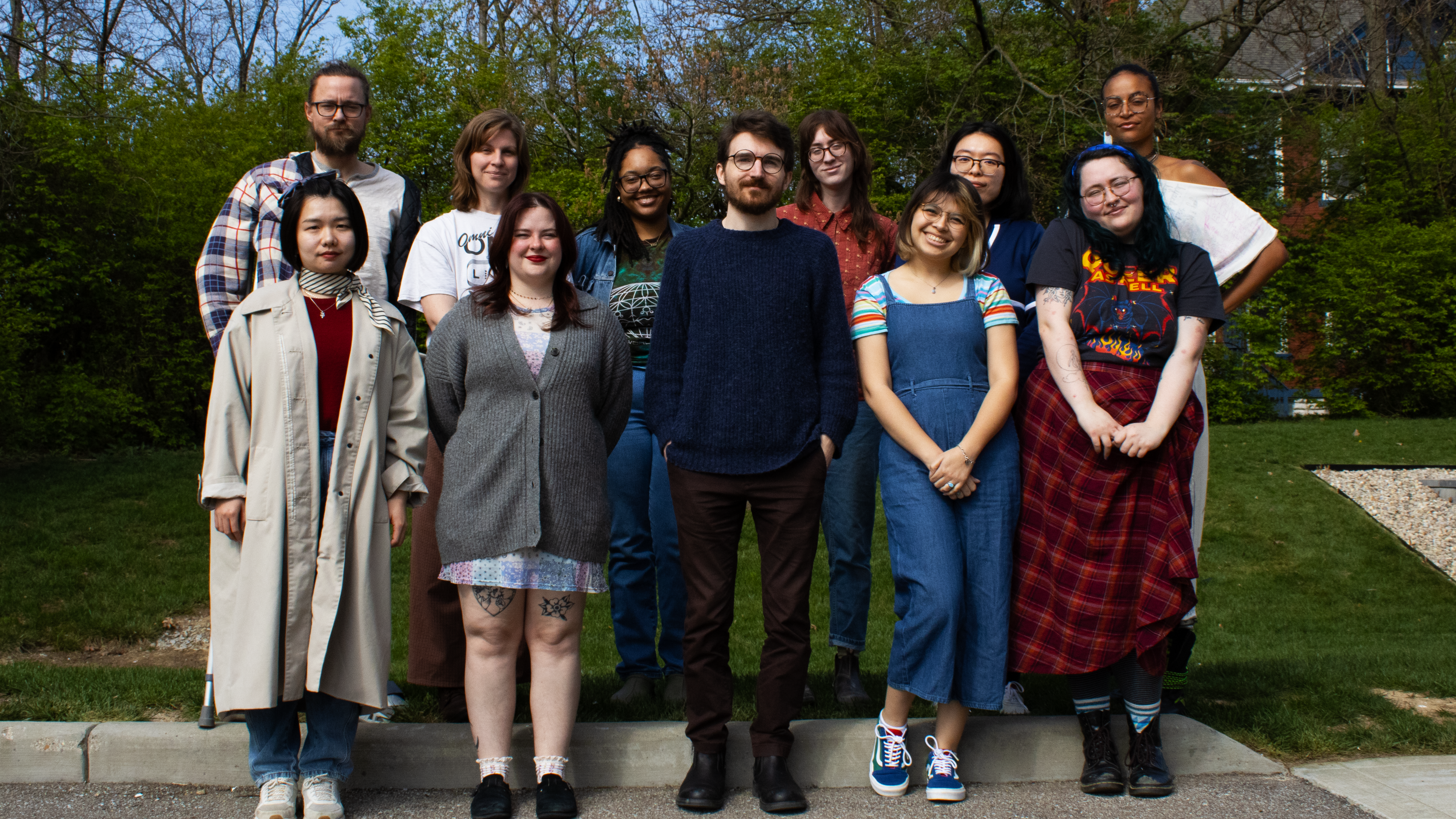 MFA Class of 2024 smiling for a group photo outside of DAAP's Studio Annex. 